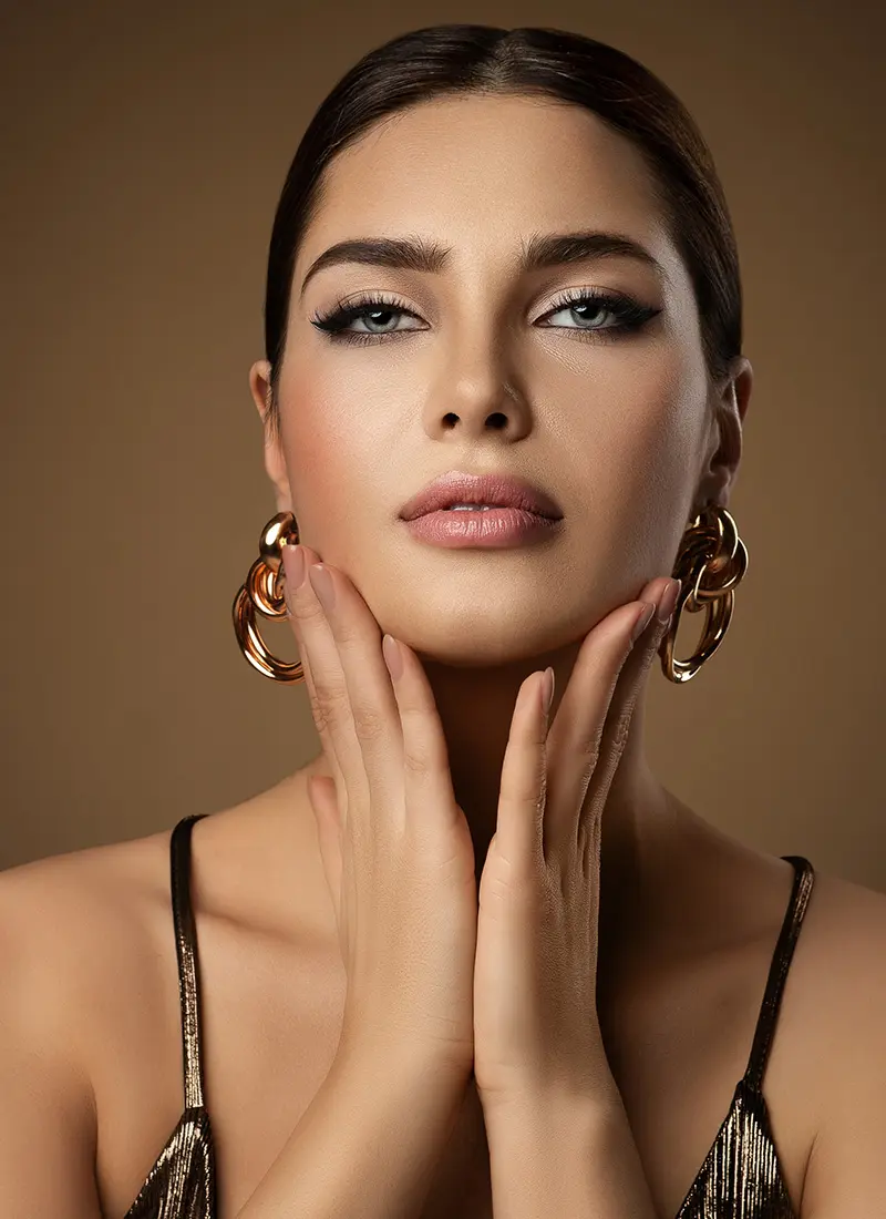 Woman with plump lips touching her face