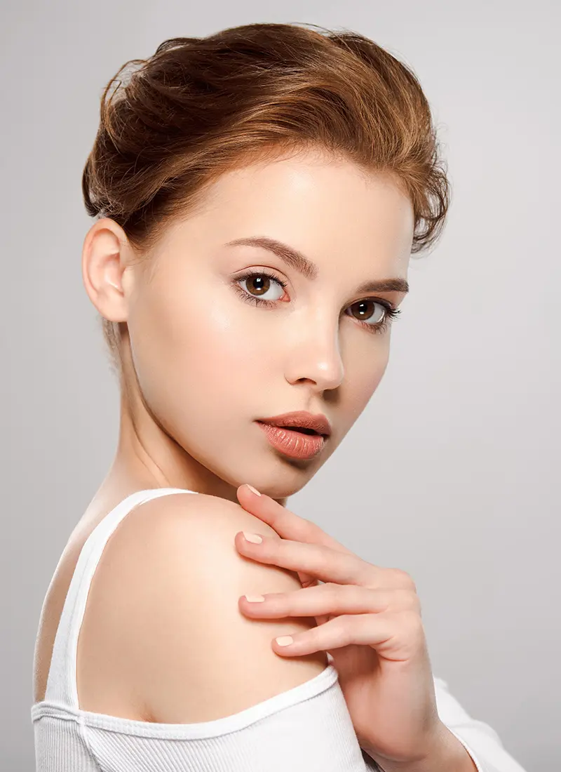 Young woman with red hair looking over her shoulder