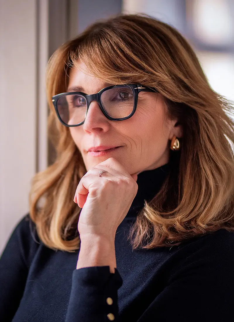 Mature woman with glasses touching her chin